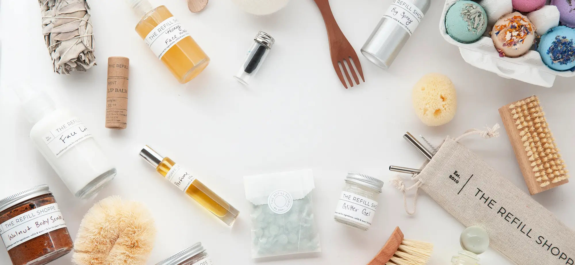 Collection of products and containers on a white surface with 'The Refill Shop' branding.
