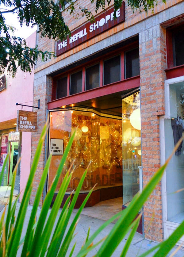 The Refill Shoppe welcoming storefront with warm window lighting.